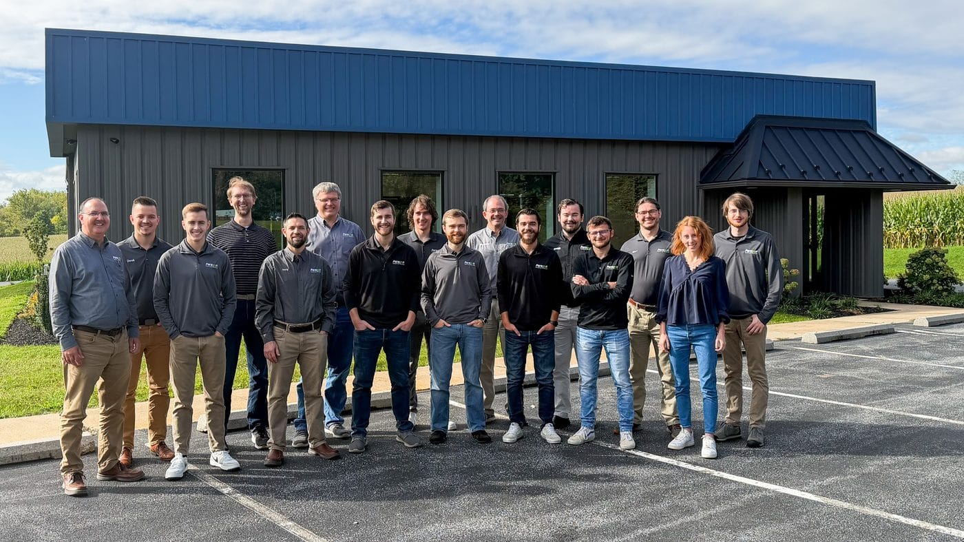 Team photo of Paragon Computing Solutions showing approximately 16 employees in front of the Paragon Office Building